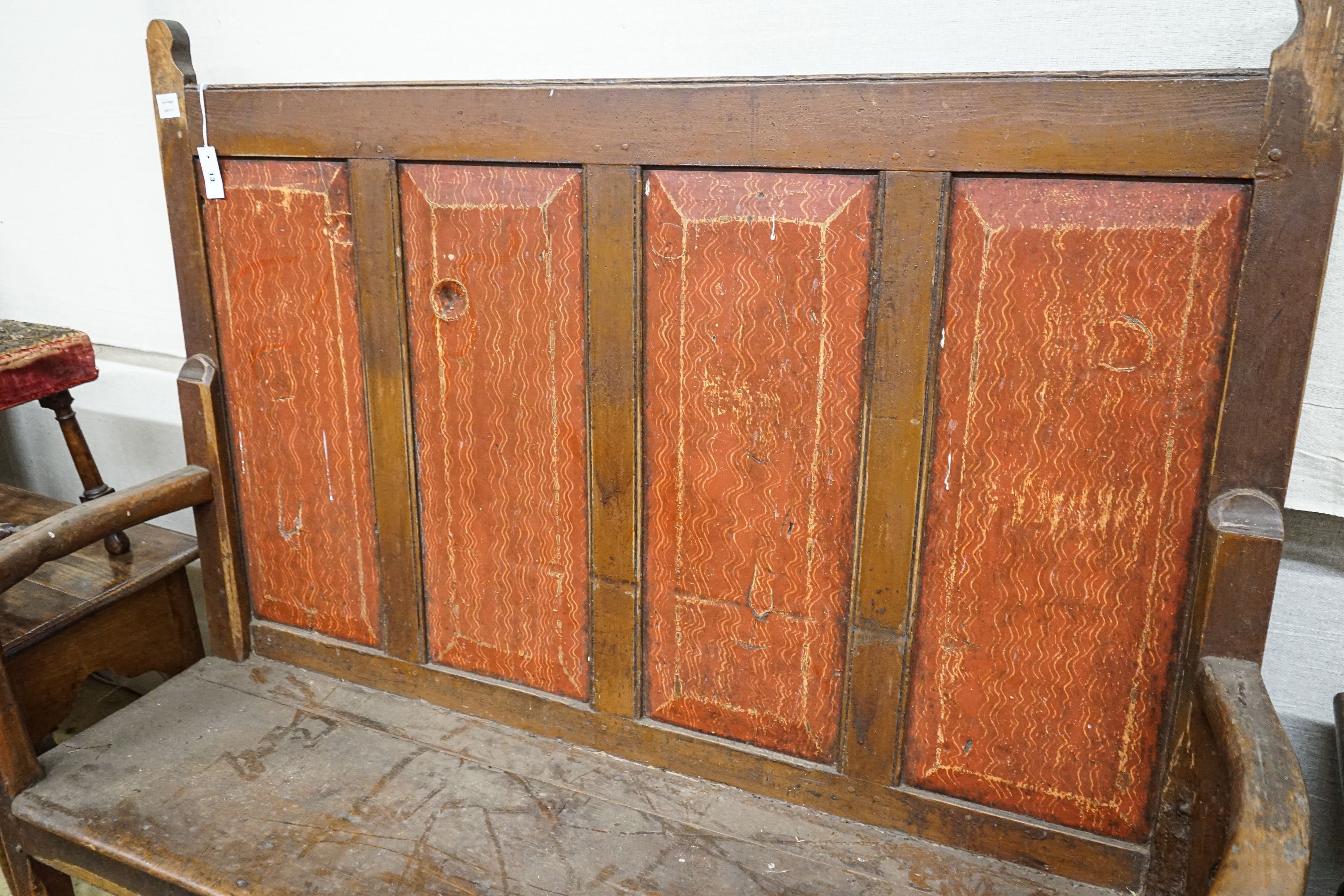 An early 19th century painted pine settle, with four panel back, scroll arms and solid seat, width 154cm, depth 49cm, height 145cm